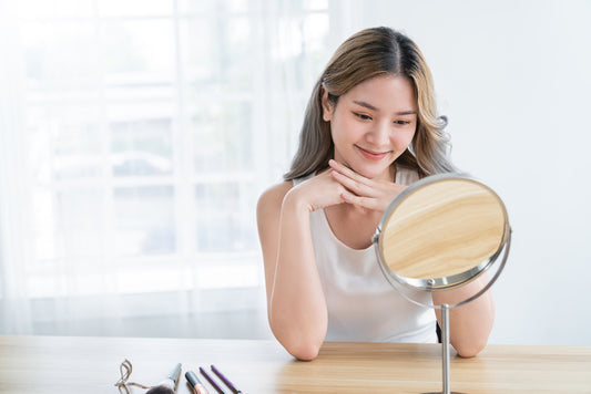 Closeup portrait of young beautiful asian girl with mirror